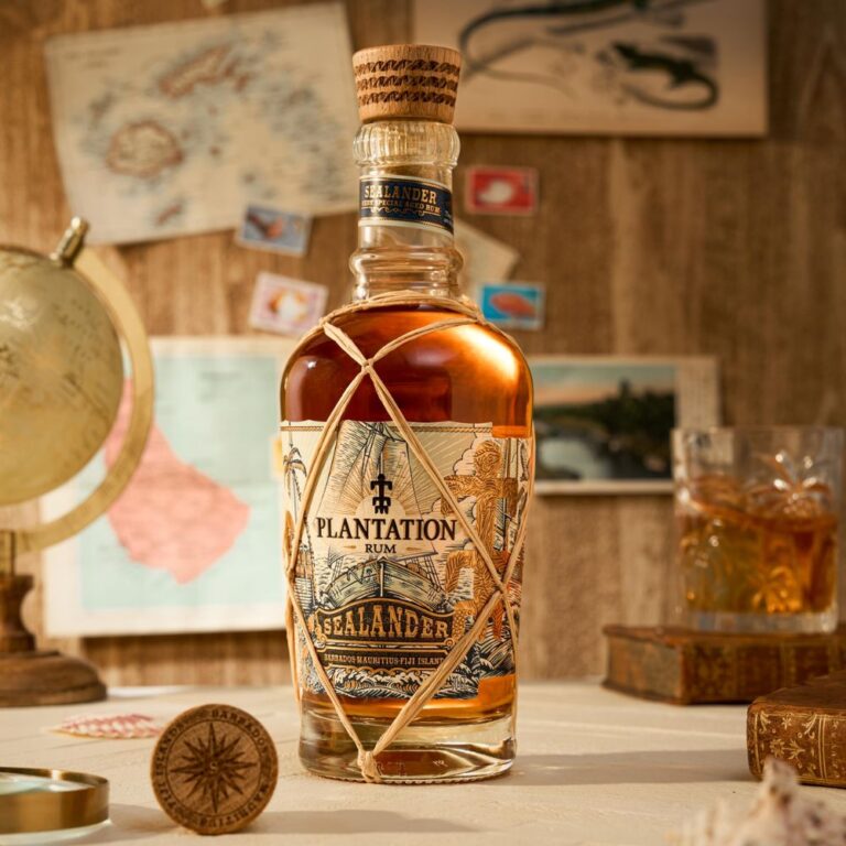 Bouteille de rhum Sealander de la marque Planteray posée sur une table, entourée d’un globe, de cartes anciennes et d’un verre de rhum, dans un décor évoquant l’exploration.
