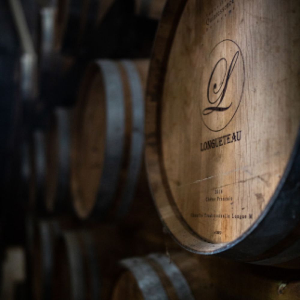 Image de la page marque de rhum agricole Longueteau sur le site Le Club des Connaisseurs : Fût de chêne marqué Longueteau dans un chai de vieillissement de rhum agricole en Guadeloupe, ambiance sombre et authentique.