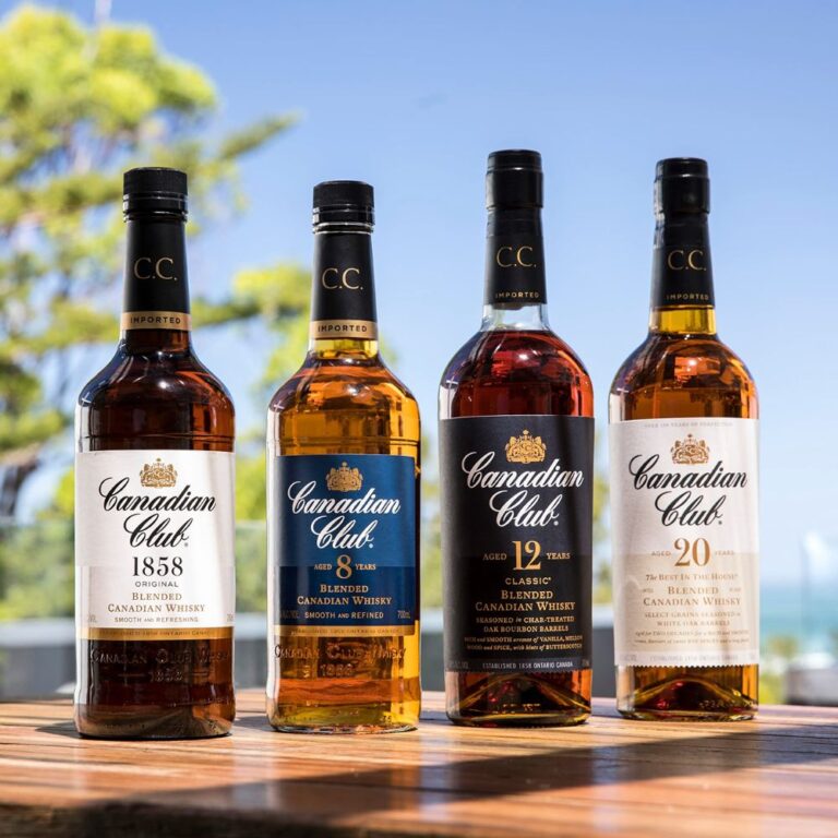 Gamme de whiskies Canadian Club en extérieur, avec les bouteilles 1858, 8 ans, 12 ans et 20 ans alignées sur une table en bois. Whiskies canadiens premium en lumière naturelle pour page marque Canadian Club pour le site Le club des Connaisseurs
