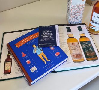 Livres sur le whisky et guide de dégustation posés sur une table, accompagnés de bouteilles de whisky, pour découvrir l’univers du whisky et enrichir ses connaissances.