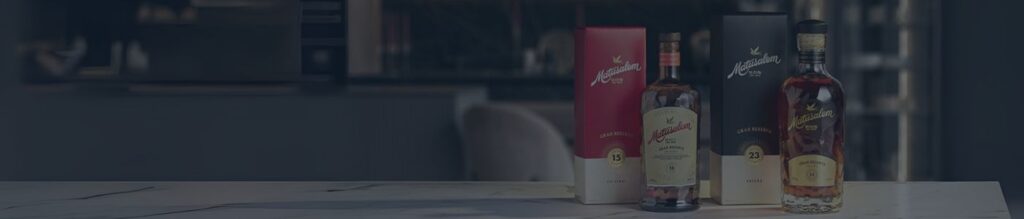 Deux bouteilles de rhum Matusalem Gran Reserva (15 et 23) posées sur un comptoir, accompagnées de leurs étuis rouge et noir, dans un cadre moderne et épuré.